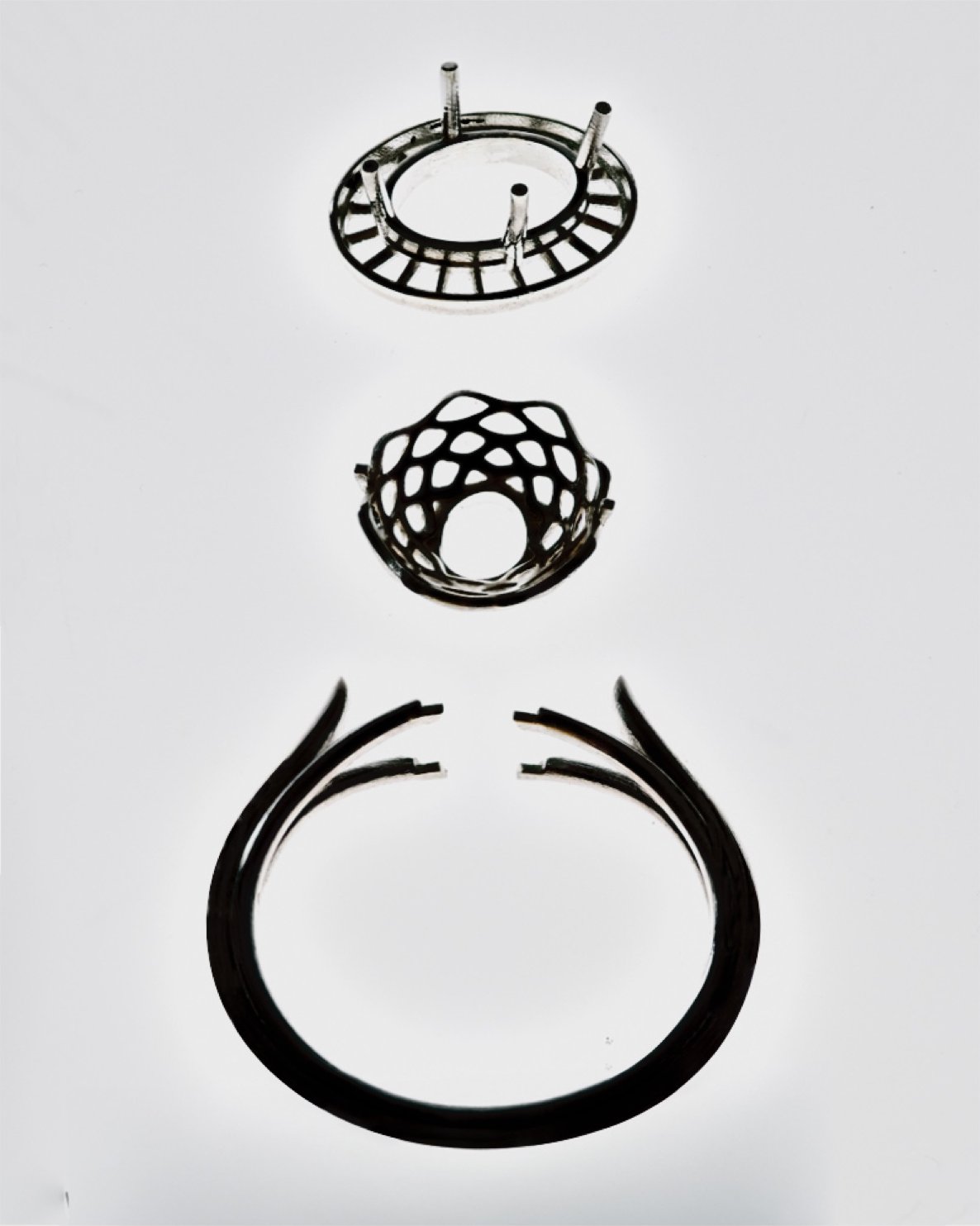 Wax and metal ring components in progress, from cast setting to finished band